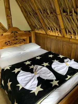 a bed with a black blanket with stars on it at Green view glamping cabin with unlimited Jacuzzi in Cocorná