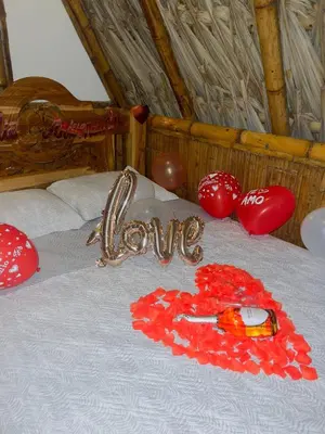 a bed with a heart and the word love on it at Green view glamping cabin with unlimited Jacuzzi in Cocorná