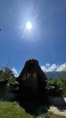 a straw hut with the sun in the sky at Green view glamping cabin with unlimited Jacuzzi in Cocorná