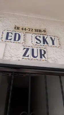 a sign on the side of a building that saysledeli sky up at exclusive pink zone sabaneta friends and fun in Sabaneta