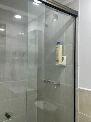 a shower with a glass door with a bottle of shampoo at exclusive pink zone sabaneta friends and fun in Sabaneta