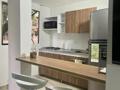a kitchen with a counter with a stove and a refrigerator at exclusive pink zone sabaneta friends and fun in Sabaneta