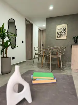 a room with a table and chairs and a vase at Edificio OA Aparta-suites in Medellín