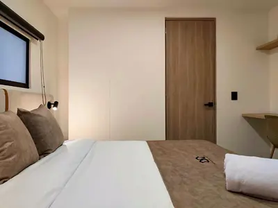 a bedroom with a large white bed and a door at Edificio OA Aparta-suites in Medellín