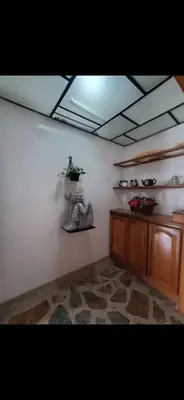 a room with a white wall with a plant on a shelf at Hostel La Casona in Medellín