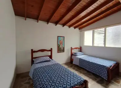 a bedroom with two beds and a window at Hostel La Casona in Medellín