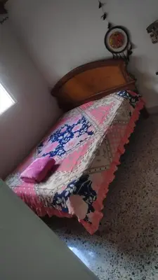 a small bed with a colorful quilt on it at Hostel La Casona in Medellín