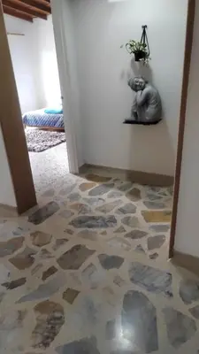 a hallway with a floor covered in rock tiles at Hostel La Casona in Medellín