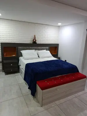 a bedroom with a large bed with a red bench at Refugio Sereno en Itagüí in Itagüí