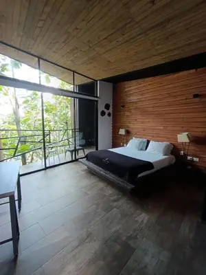 a bedroom with a large bed and a large window at Madeira Majestic Hotel in Doradal