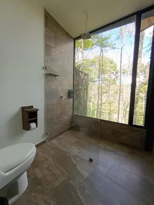 a bathroom with a shower and a toilet and a window at Madeira Majestic Hotel in Doradal