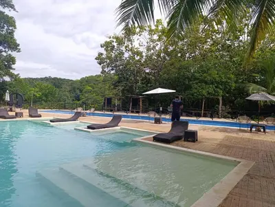 a man standing in front of a swimming pool at Madeira Majestic Hotel in Doradal