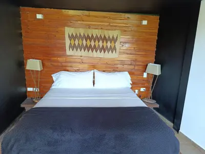 a large bed with a wooden headboard and two lamps at Madeira Majestic Hotel in Doradal
