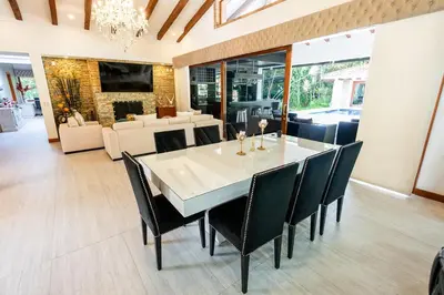 a dining room with a white table and black chairs at Finca la Princesa Eastern Antioquia in Carmen de Viboral