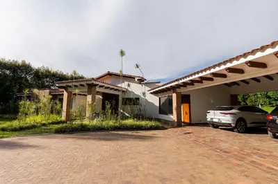 a house with a car parked in a driveway at Finca la Princesa Eastern Antioquia in Carmen de Viboral