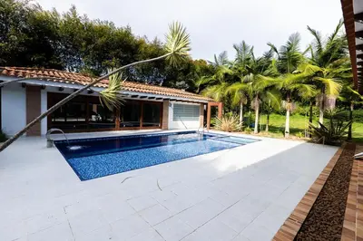 a swimming pool in a yard next to a house at Finca la Princesa Eastern Antioquia in Carmen de Viboral