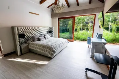 a bedroom with a bed and a desk with a desk at Finca la Princesa Eastern Antioquia in Carmen de Viboral