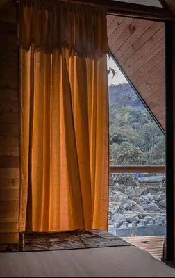 a bedroom with a window with an orange curtain at La Chorrera ecohotel in Cocorná