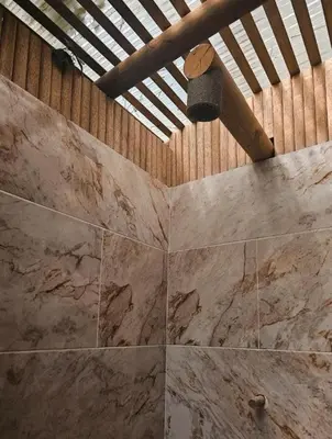 a room with a stone wall and a ceiling at La Chorrera ecohotel in Cocorná