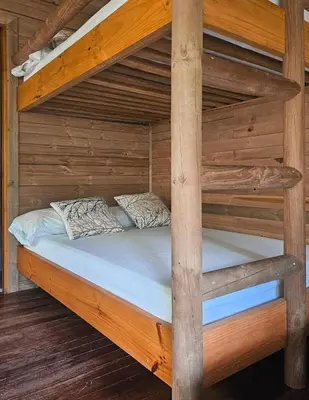 a bunk bed in a cabin with wooden walls at La Chorrera ecohotel in Cocorná