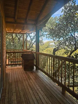 a porch of a cabin with a bench on it at La Chorrera ecohotel in Cocorná