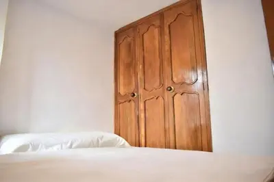 a bedroom with a wooden door next to a bed at Habitación con cama nueva doble y balcón privado cerca del parque principal in La Ceja