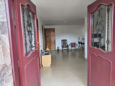 a red door in a room with a living room at Habitación con cama nueva doble y balcón privado cerca del parque principal in La Ceja