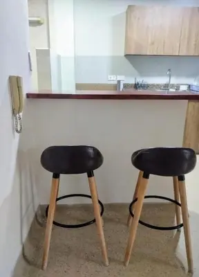 two black stools sitting next to a kitchen counter at Habitación con cama nueva doble y balcón privado cerca del parque principal in La Ceja