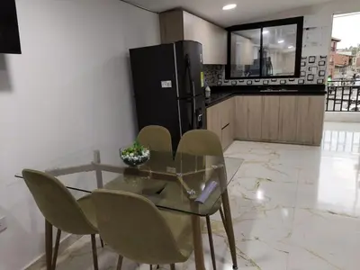a glass table and chairs in a kitchen with a refrigerator at Hermoso apartamento en la Dalia Marinilla Antq in Marinilla