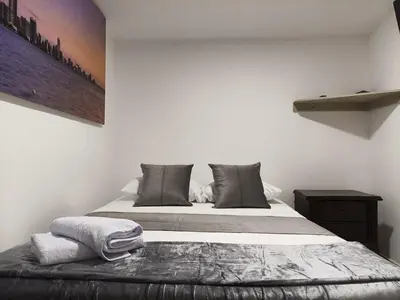 a bed in a white room with at Hermoso apartamento en la Dalia Marinilla Antq in Marinilla