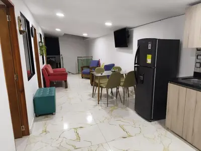 a living room with a table and a refrigerator at Hermoso apartamento en la Dalia Marinilla Antq in Marinilla