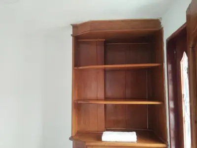 a wooden book shelf in a room at Cama nueva doble con balcón cerca del parque principal in La Ceja