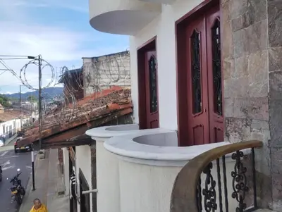 a balcony of a building with a red door at Cama nueva doble con balcón cerca del parque principal in La Ceja