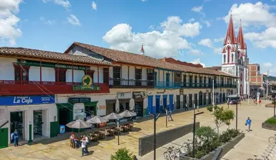 a street in a town with a church in the background at Cama nueva doble con balcón cerca del parque principal in La Ceja