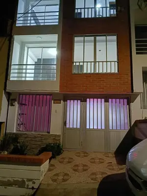 a house with pink and purple doors on it at Hostal Villa Café in Manizales