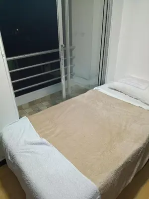 a bed in a room with a glass window at Hostal Villa Café in Manizales