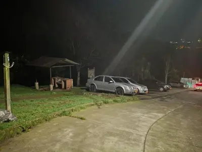 a couple of cars parked in a parking lot at night at Hostal Villa Café in Manizales