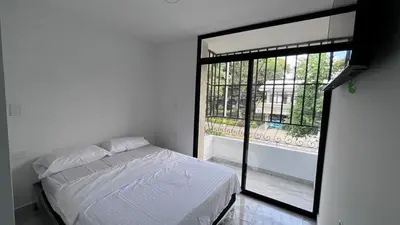 a bedroom with a bed and a large window at Loft Medellin a Dos Calles del Estadio in Medellín