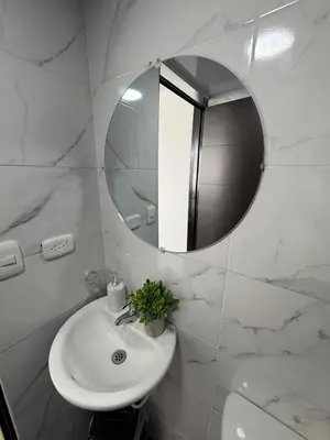 a white bathroom with a sink and a mirror at Descansa, comodidad y confort in Manizales