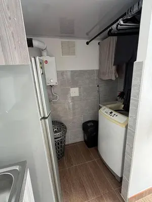 a small kitchen with a sink and a refrigerator at Descansa, comodidad y confort in Manizales
