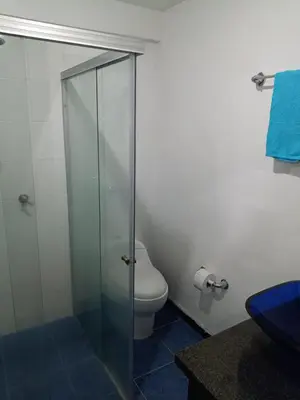 a bathroom with a toilet and a glass shower at Hostal Villa Café in Manizales