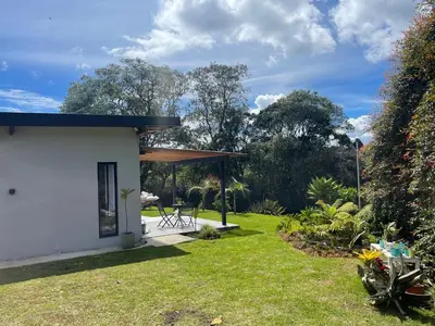 a garden with a pavilion and a house at Santa Elena casa pino in Medellín