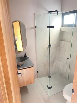 a bathroom with a glass shower and a sink at Santa Elena casa pino in Medellín