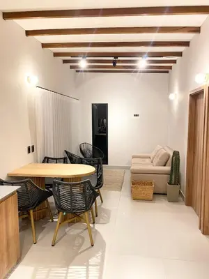 a living room with a table and chairs and a couch at Santa Elena casa pino in Medellín