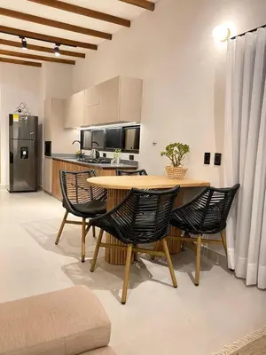 a kitchen and dining room with a table and chairs at Santa Elena casa pino in Medellín