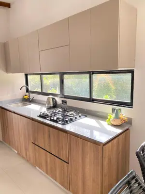 a kitchen with a stove and three windows at Santa Elena casa pino in Medellín