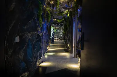 a tunnel in a cave with lights on the wall at The rock complete apartment in Medellín