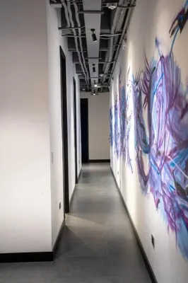 a hallway with paintings on the walls of a building at The rock complete apartment in Medellín