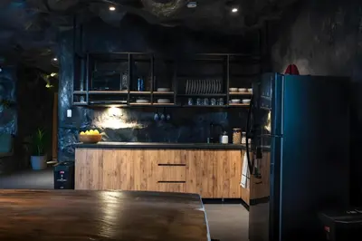 a kitchen with a black refrigerator and wooden cabinets at The rock complete apartment in Medellín
