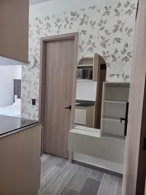 a room with a door to a kitchen with a staircase at Beautiful Laureles Studio Apartment in Medellín